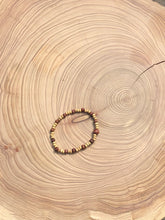 Load image into Gallery viewer, Handmade beaded bracelet on elastic. Made out of delicate small wooden recycled beads.