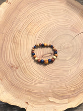 Load image into Gallery viewer, handmade beaded bracelet on elastic. Made out blue, brown and beige recycled beads.