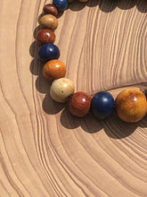 Load image into Gallery viewer, handmade beaded bracelet on elastic. Made out blue, brown and beige recycled beads.
