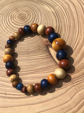 Load image into Gallery viewer, handmade beaded bracelet on elastic. Made out blue, brown and beige recycled beads.